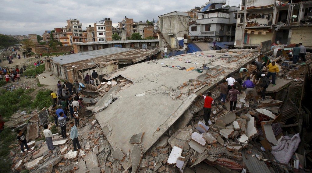 Image: People gather near a collapsed house after major earthquake in Kathmandu